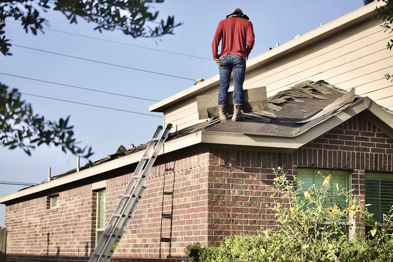 Professional roofer working on a residential roof in Mock